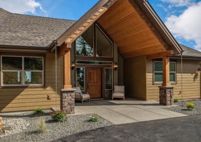 North Ridge Homes Eaglecrest plan's front entrance with a large front patio and overhang, very rustic, wooden and angular structure