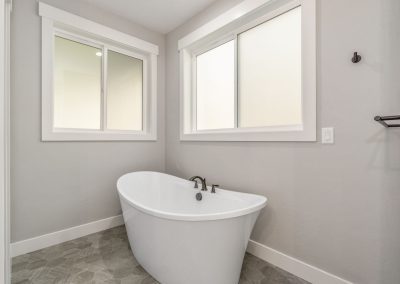 A white bathtub in a bathroom with gray walls.