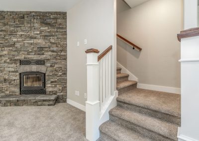 A home with a stone fireplace and stairs.