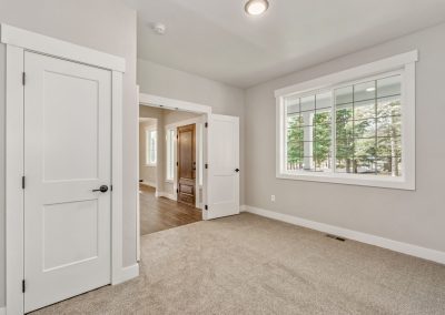 A room with a white door and carpet.