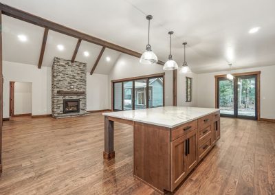 A large open kitchen with wood floors and a fireplace.