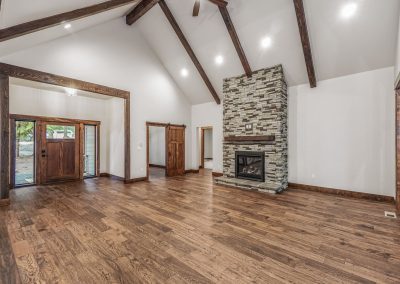 An empty living room with wood floors and a fireplace.