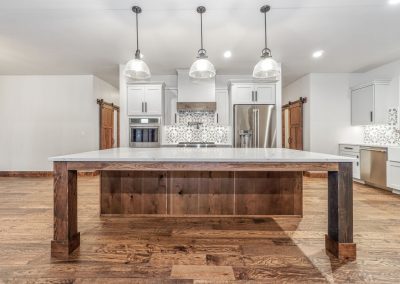 A kitchen with wood floors and a large island.