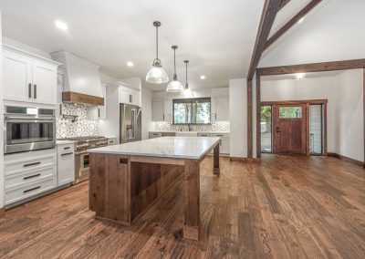 A kitchen with wood floors and wooden beams.