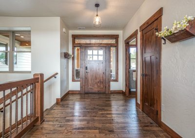 A hallway with wood floors and a wooden door.
