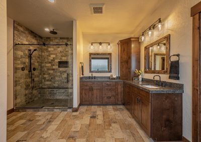 A bathroom with wood floors and a shower stall.