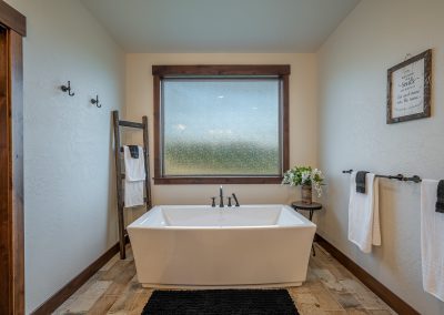 A bathroom with a bathtub and a window.