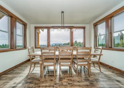A dining room with a large window overlooking the mountains.