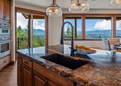 A kitchen with granite counter tops and a view of the mountains.