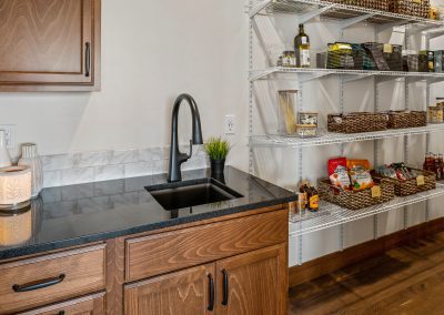 A kitchen with shelves and a sink.