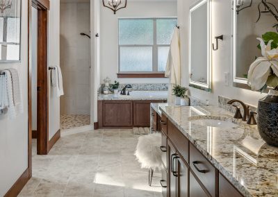 A bathroom with granite counter tops and a large mirror.