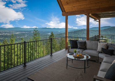 A deck with furniture overlooking a mountain view.