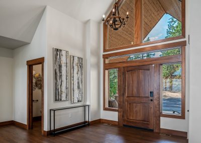 The entryway of a home with wood floors and a large window.