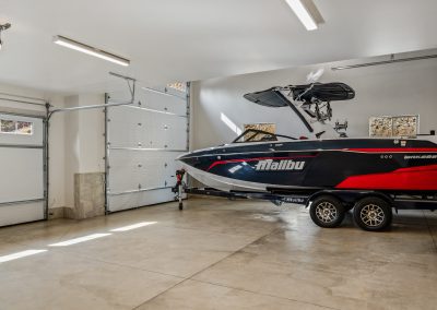 A boat is parked in a garage with a garage door.