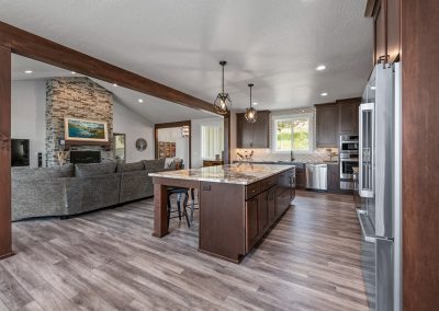 A large kitchen with wood floors and a stone fireplace.