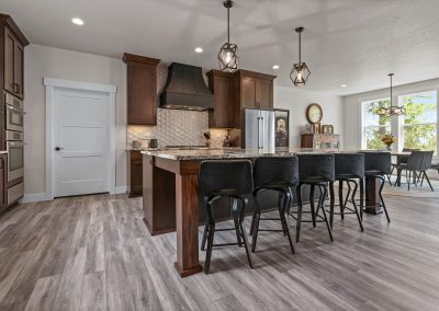 A kitchen with hardwood floors and bar stools.