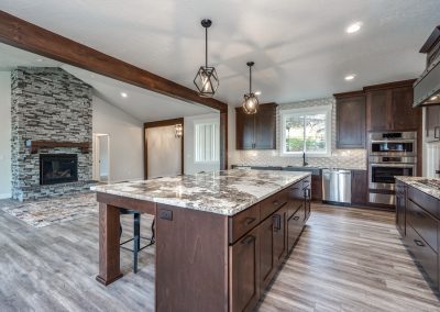 A large kitchen with wood cabinets and a stone fireplace.