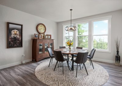 A dining room with hardwood floors and a round table.