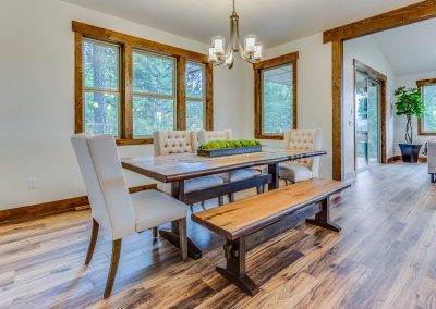 A dining room with hardwood floors and a bench.