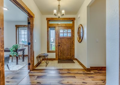 A hallway with wood floors and a door.