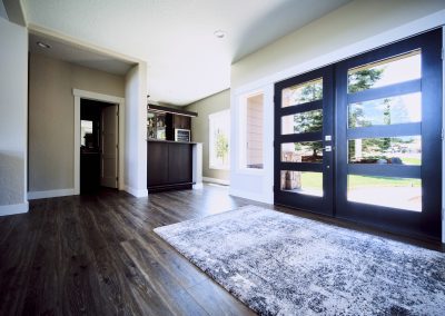 An entryway with hardwood floors and a black door.