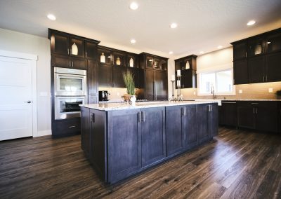 A kitchen with dark cabinets and hardwood floors.