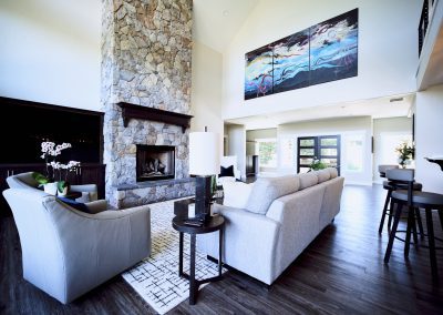 A large living room with a stone fireplace.