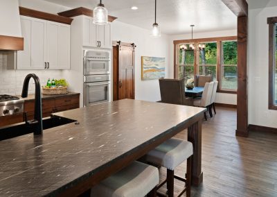 A kitchen with black counter tops and wooden cabinets.