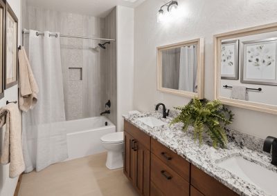 A bathroom with granite counter tops and a bathtub.