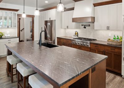 A kitchen with a marble counter top and wooden cabinets.