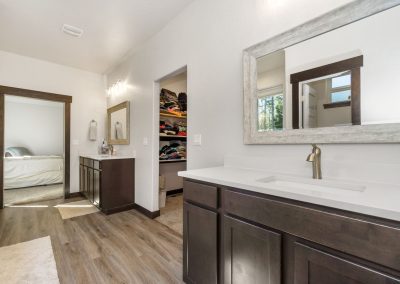 A bathroom with wood floors and a mirror.