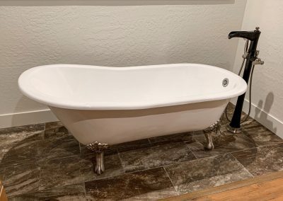 A white bathtub sitting on top of a tile floor.