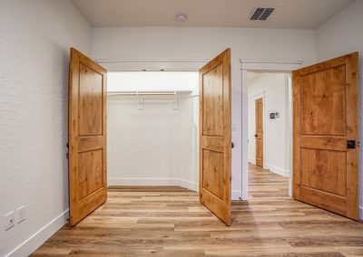 A hallway with wooden doors and hardwood floors.