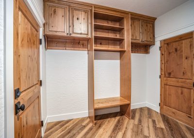 A mudroom with wooden cabinets and a wooden floor.