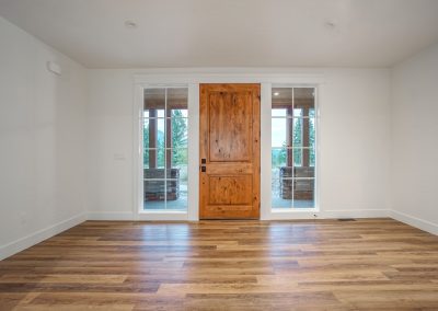 An empty room with wood floors and a wooden door.