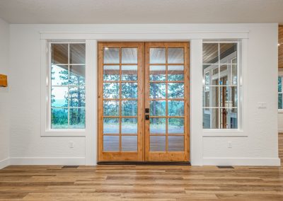 French doors in a home with hardwood floors and a fireplace.