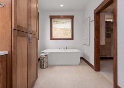 A bathroom with wooden cabinets and a tub.