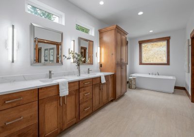 A bathroom with wooden cabinets and a tub.