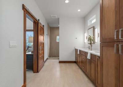 A bathroom with wood cabinets and a mirror.