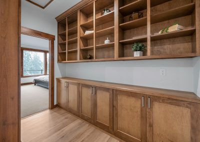 A hallway with wooden cabinets and a sliding glass door.
