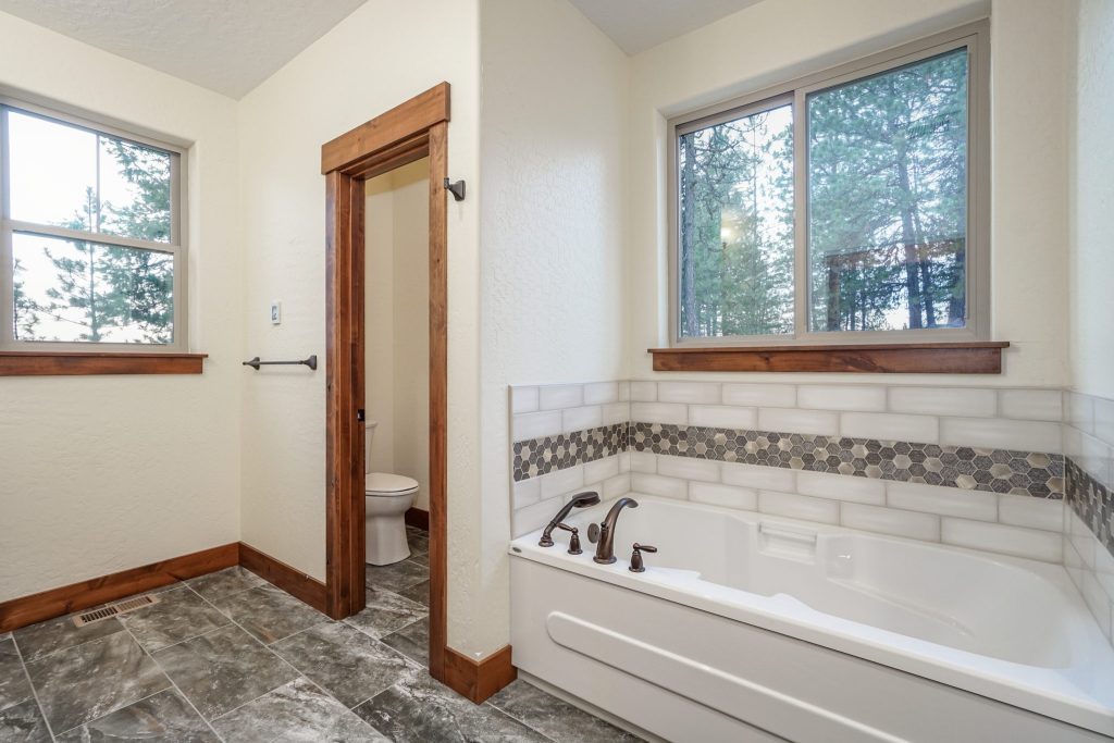 A bathroom with a tub and a window.