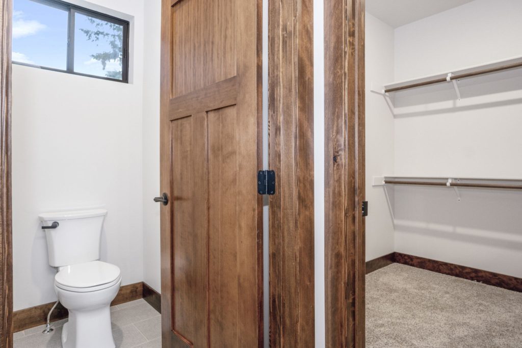 A bathroom with a toilet and a closet.