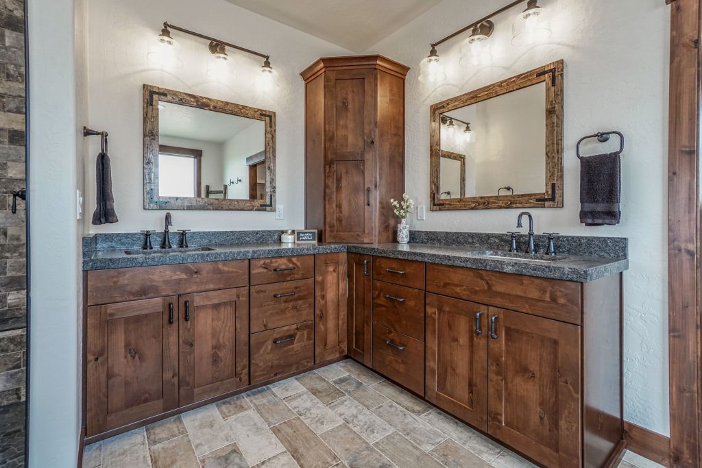 A bathroom with wooden cabinets and granite counter tops.
