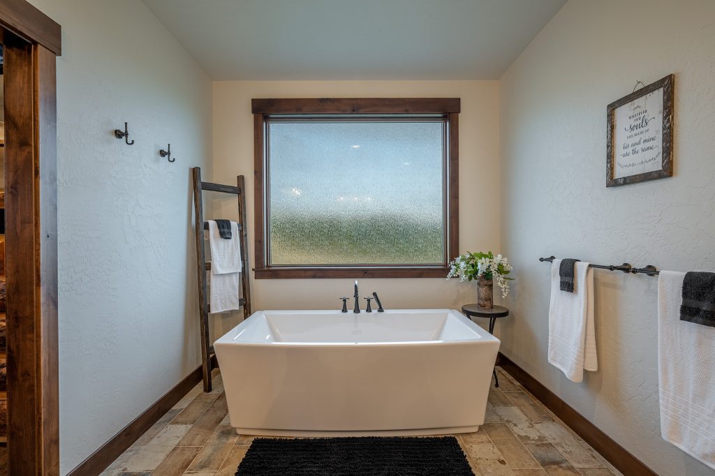 A bathroom with a bathtub and a window.