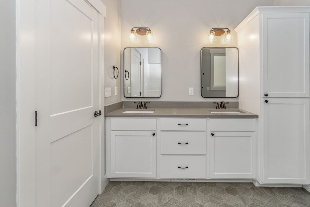 A white bathroom with two sinks and mirrors.