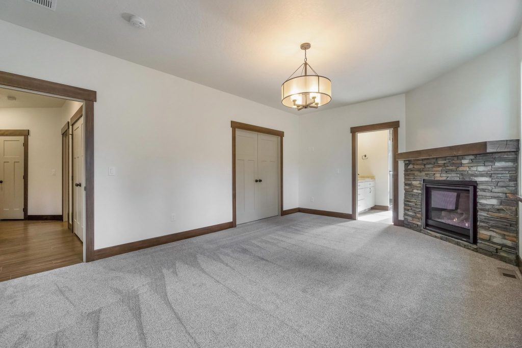An empty room with a fireplace and a stone wall.