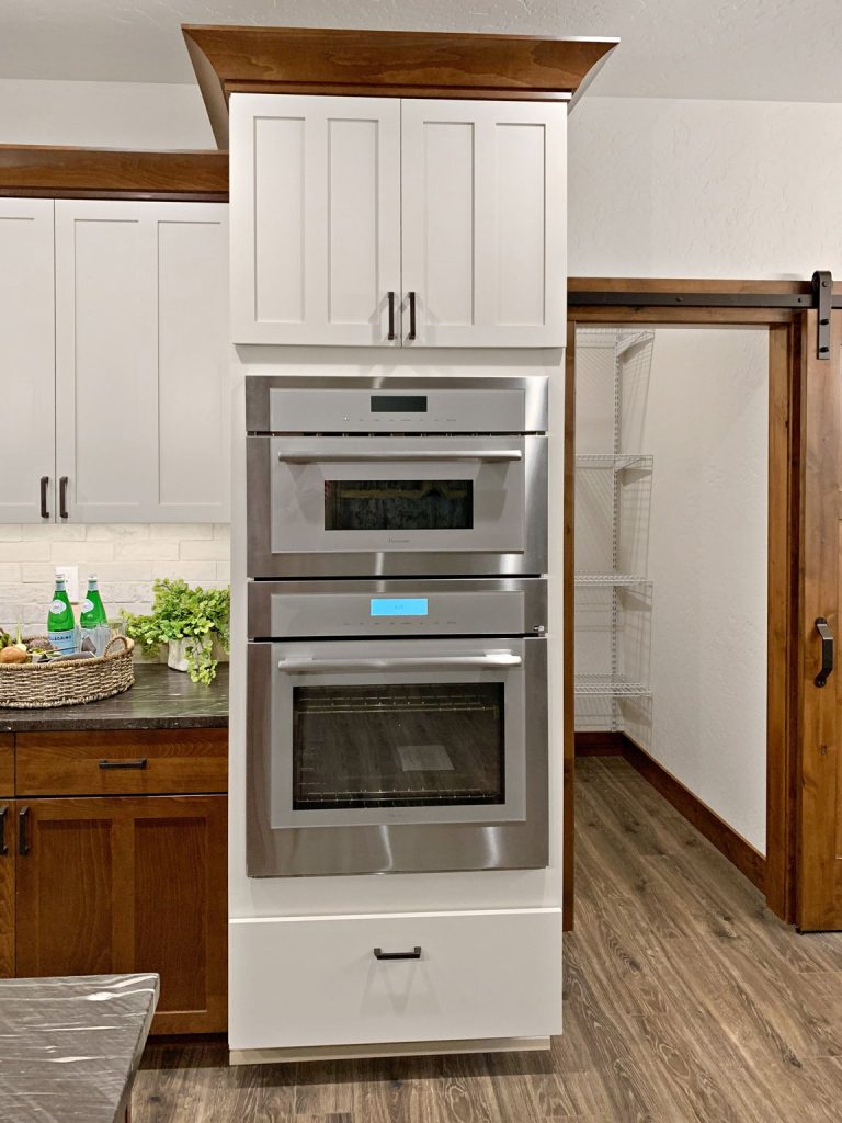 A white kitchen with a stainless steel oven.