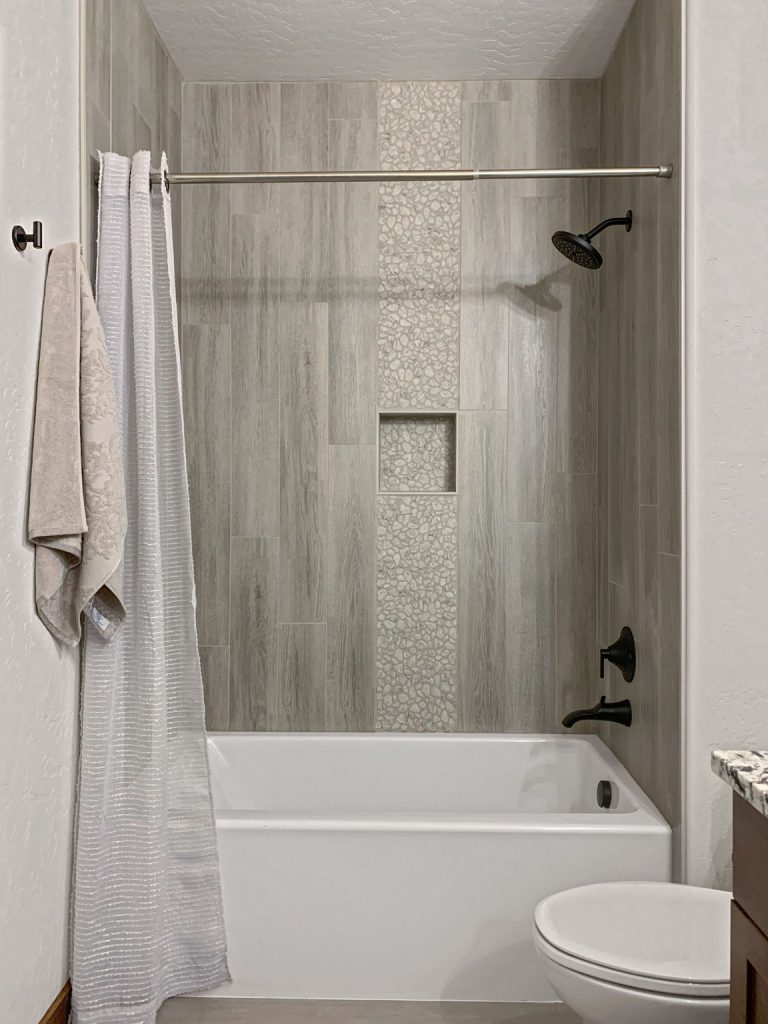 A bathroom with a tub, shower, and sink.