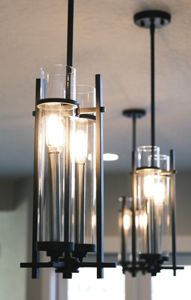 Three light fixtures hanging from the ceiling in a kitchen.