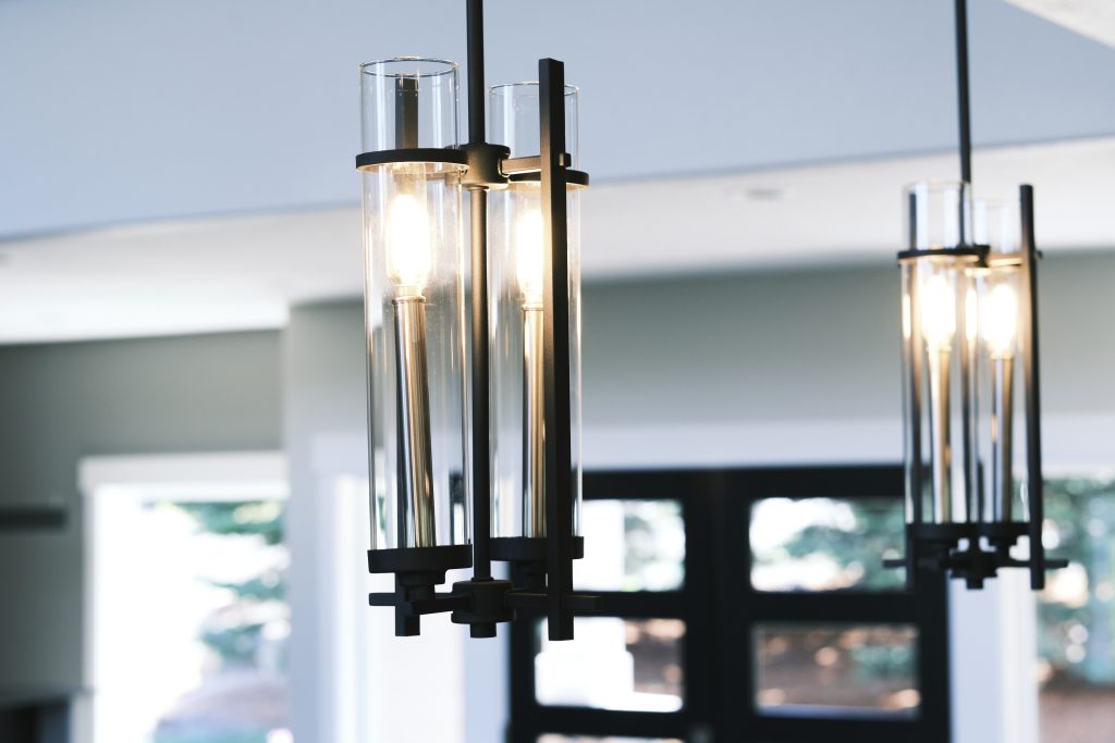 Two pendant lights hanging over a dining room table.
